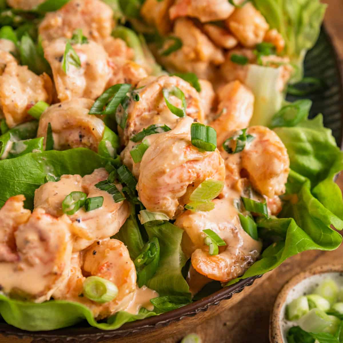 a close up showing bang bang sauce on shrimp lettuce wraps.