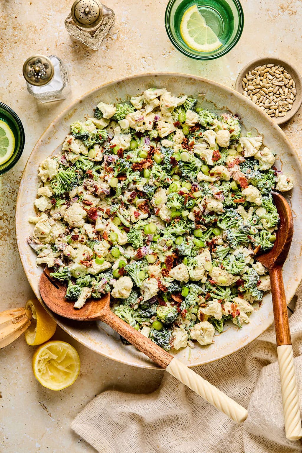An overhead shot of the easy Cauliflower and Broccoli Salad in a bowl with ingredients surrounding it.