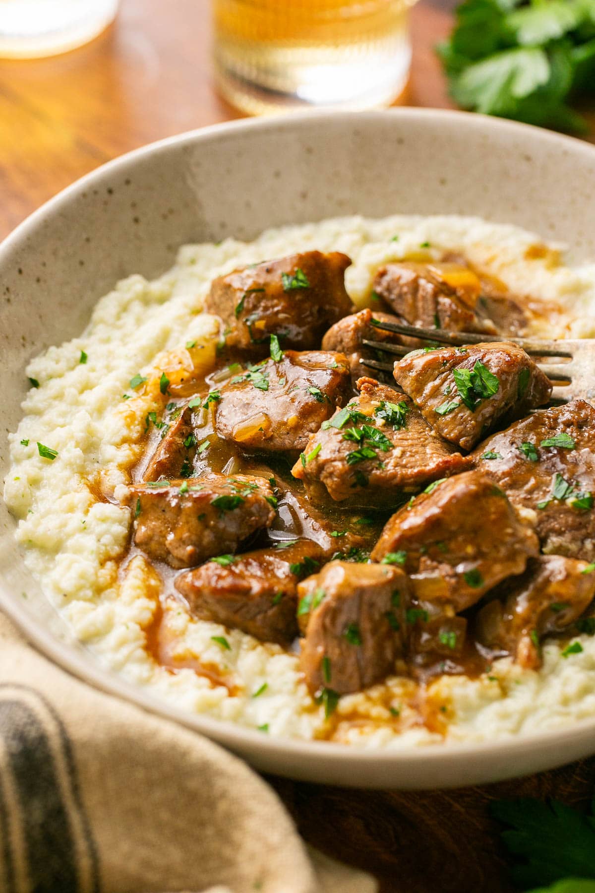 a close up photo of the bowl of beef tips and cauliflower mash