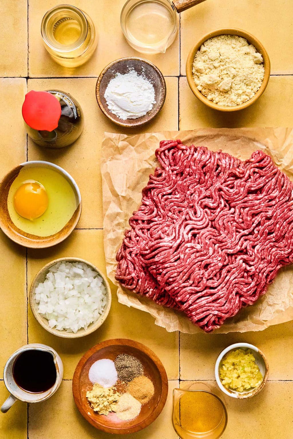 Ingredients for Asian meatballs set on a light brown square tile counter top.