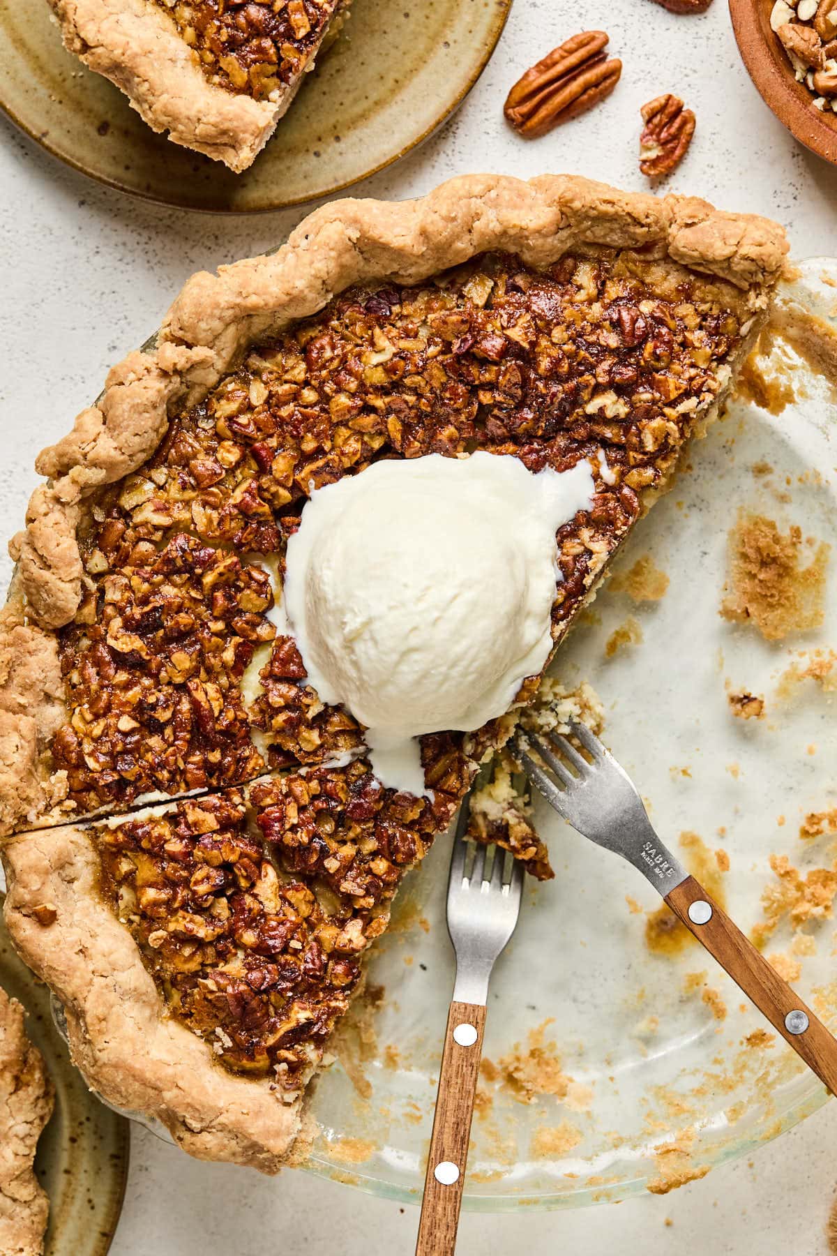 half of a creamy pecan pie topped with a scoop of ice cream. 