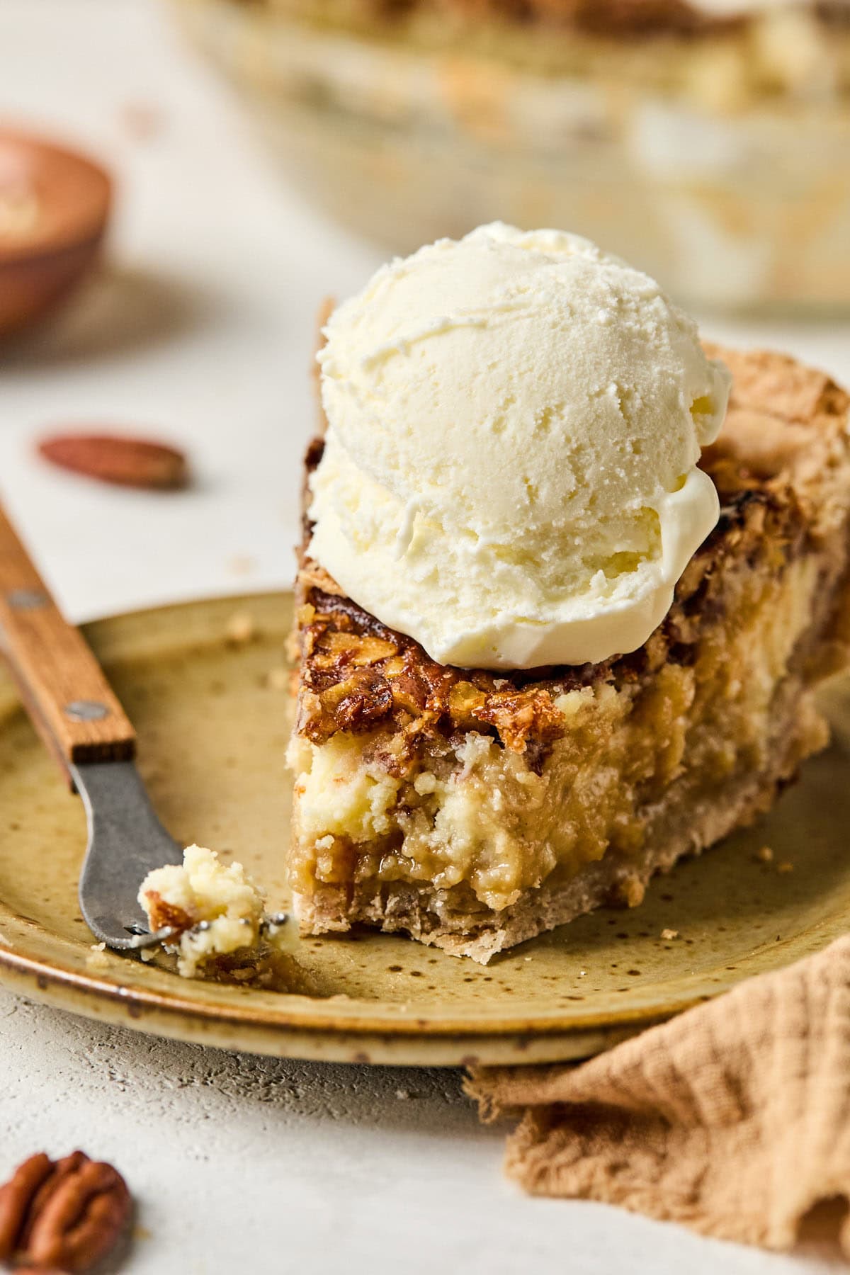 a fork holding a bite of pecan pie on the end. 