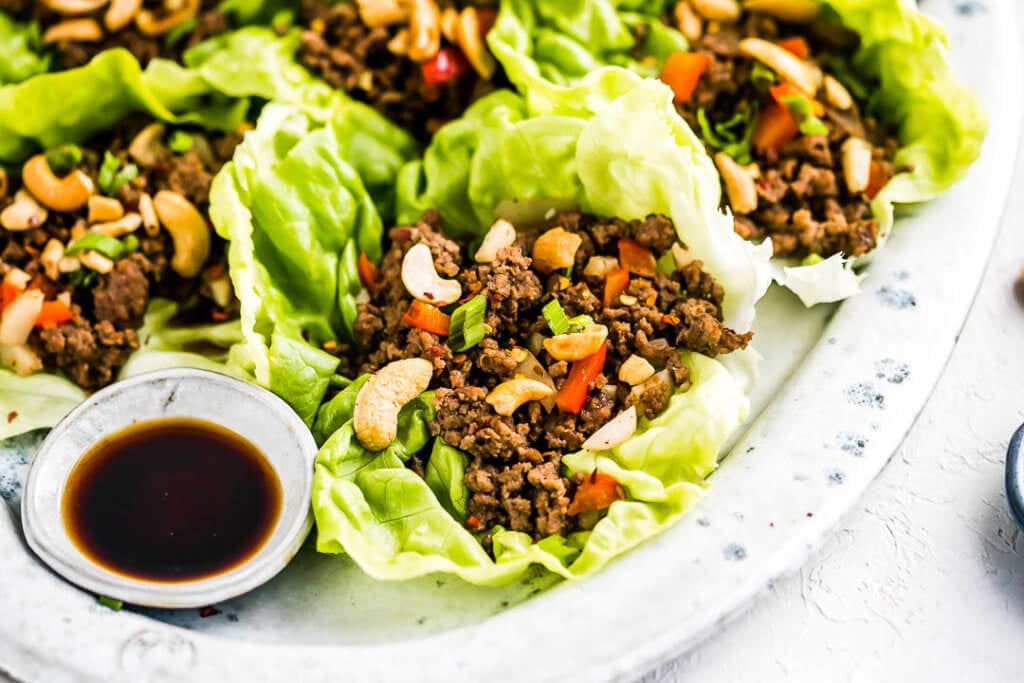 butter lettuce wraps filled with ground beef and topped with cashews and green onions