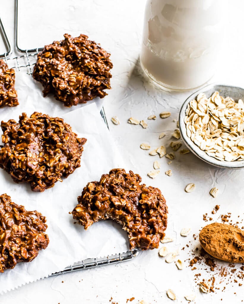 a bunch of cookies on a piece of parchment paper with a bite taken out of one. 