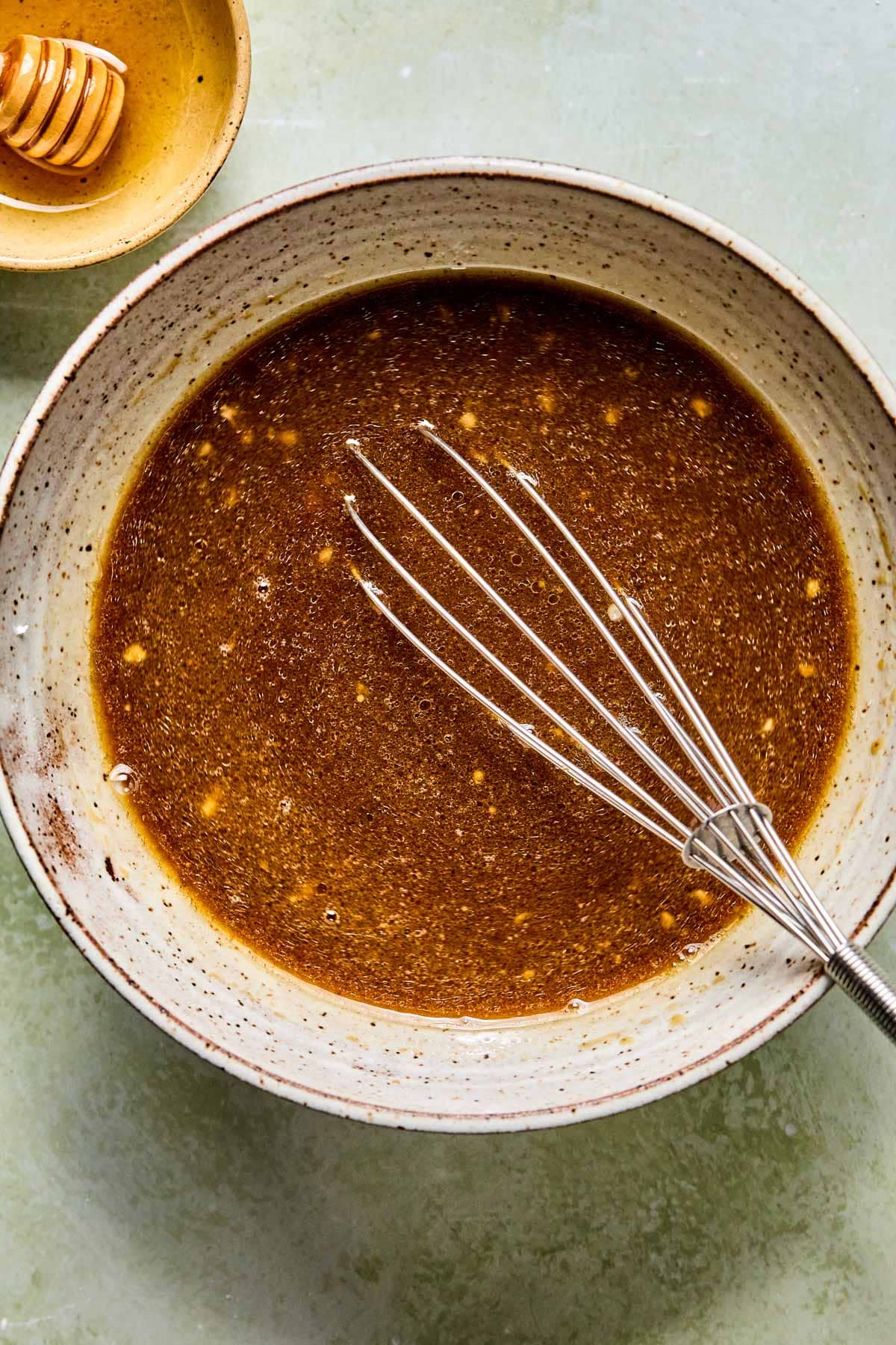 Whisking coconut aminos, rice vinegar, garlic, ginger, sesame oil, arrowroot, and water for kung pao sauce.