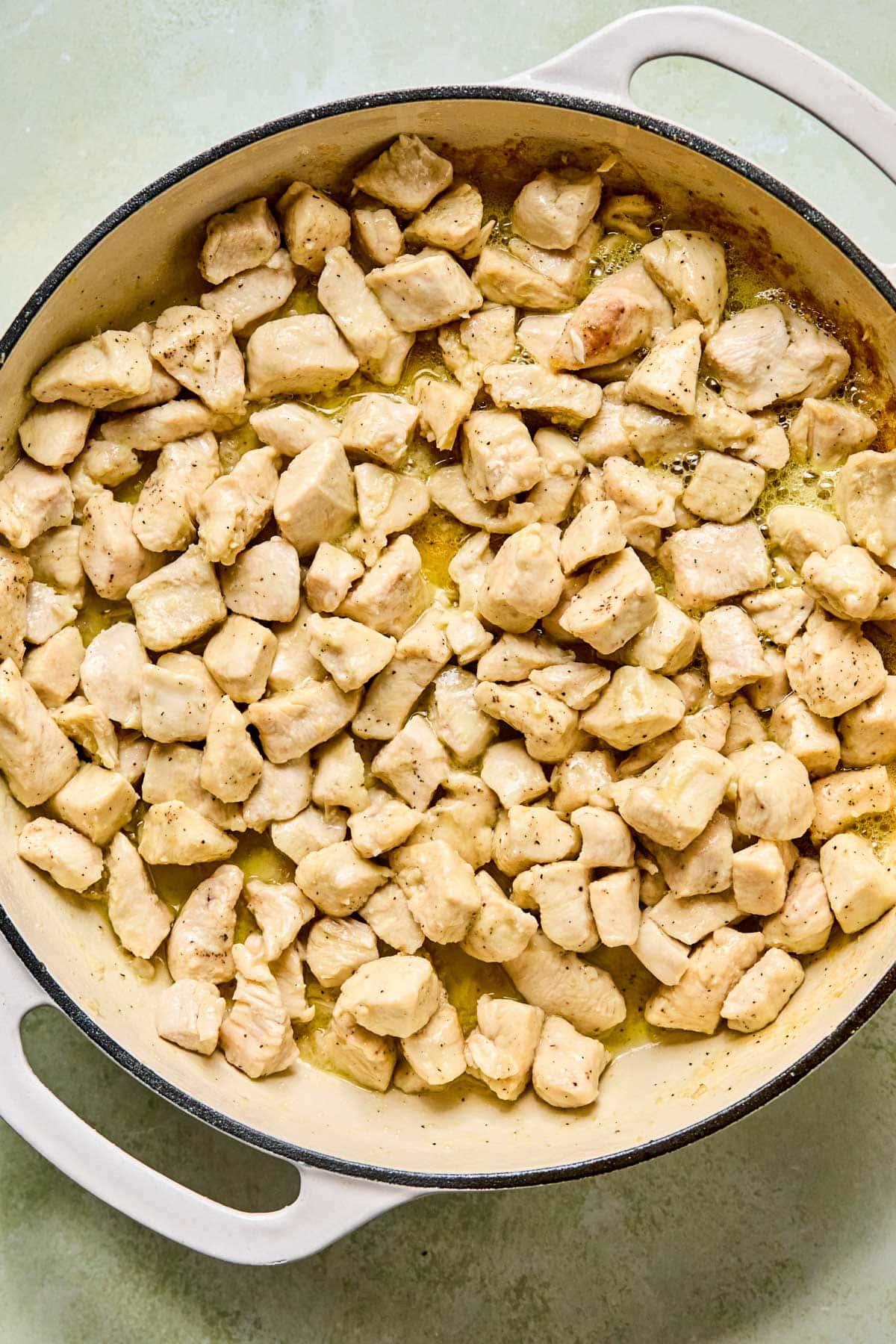 Chicken searing in a hot skillet until golden brown.