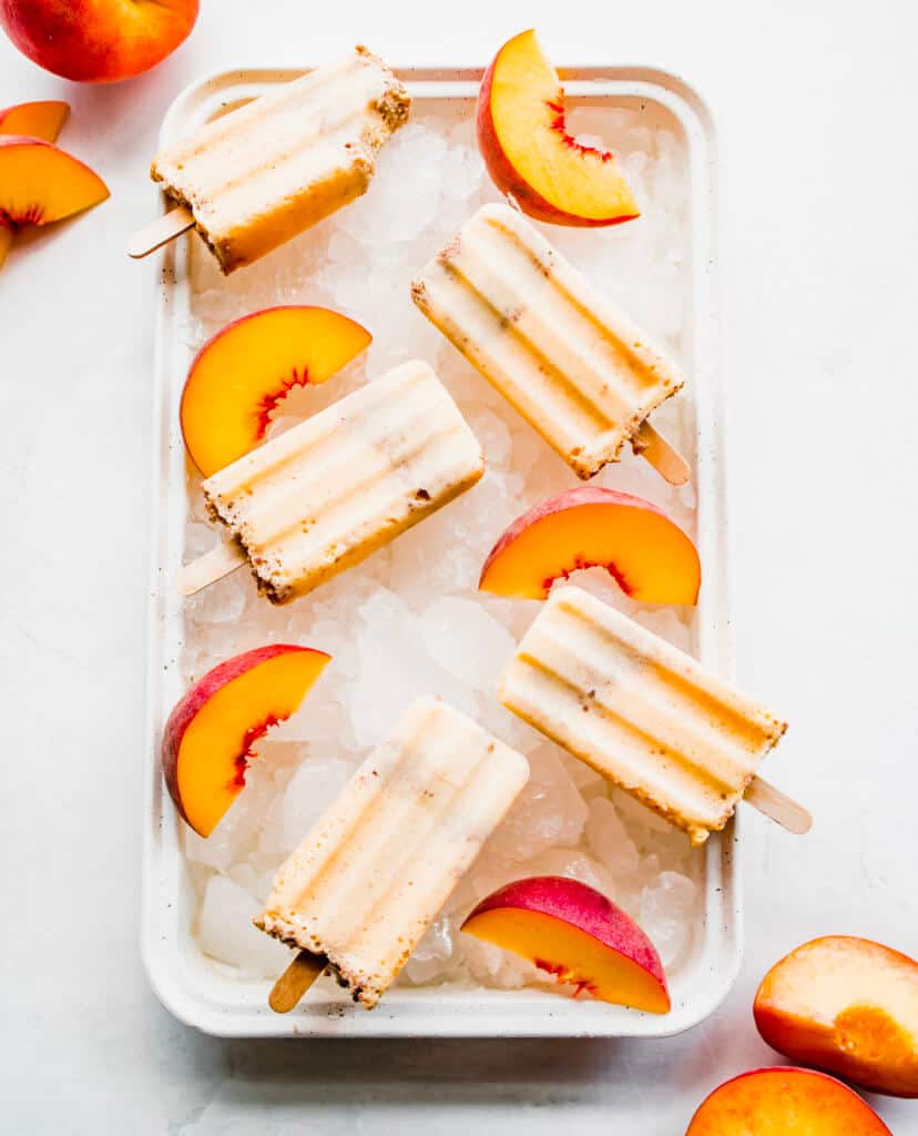 A frozen treat on a tray with ice and sliced peaches