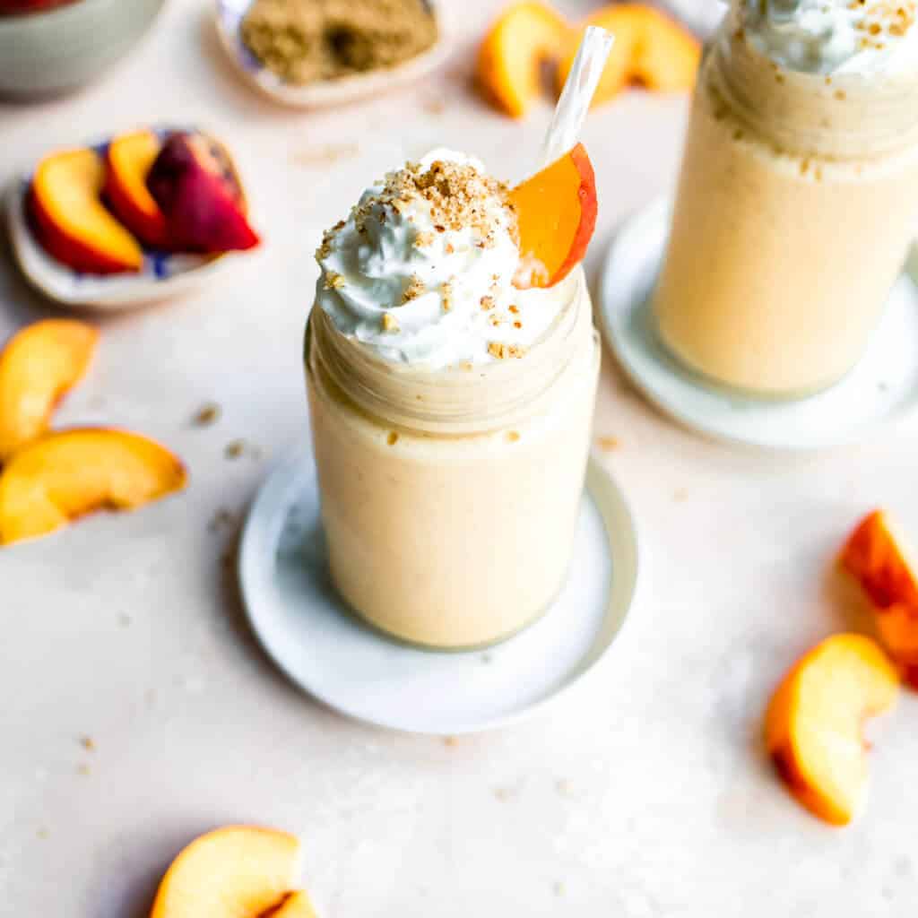 Peaches and Cream Smoothies with whipped cream and pecan crisp topping