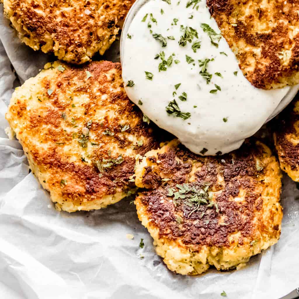 A circle tray of fritters made out of cauliflower and homemade ranch dressing