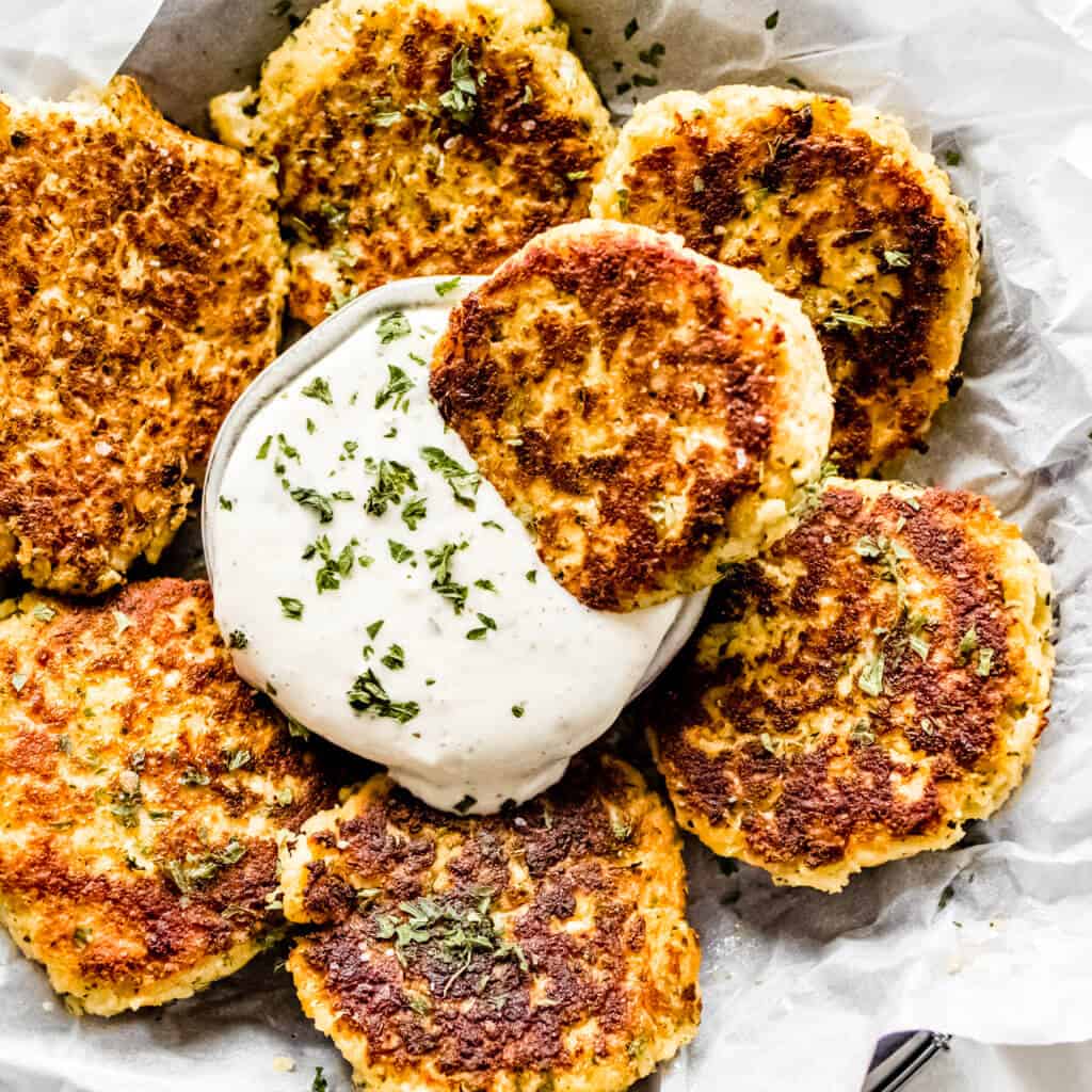 A circle tray of fritters made out of cauliflower and homemade ranch dressing