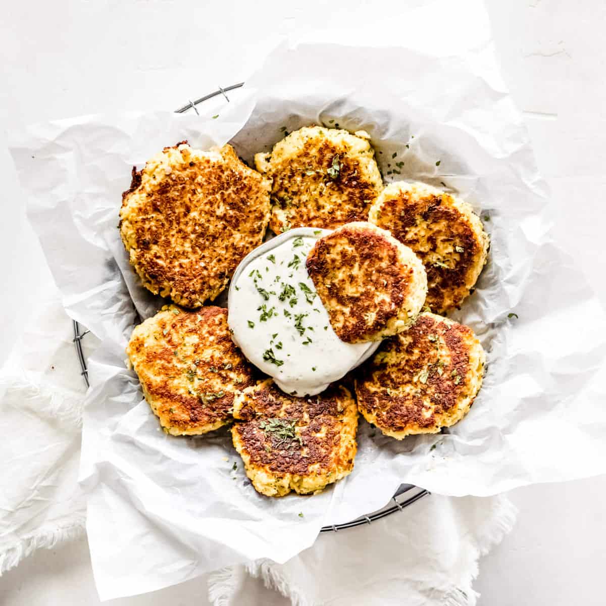 A circle tray of fritters made out of cauliflower and homemade ranch dressing
