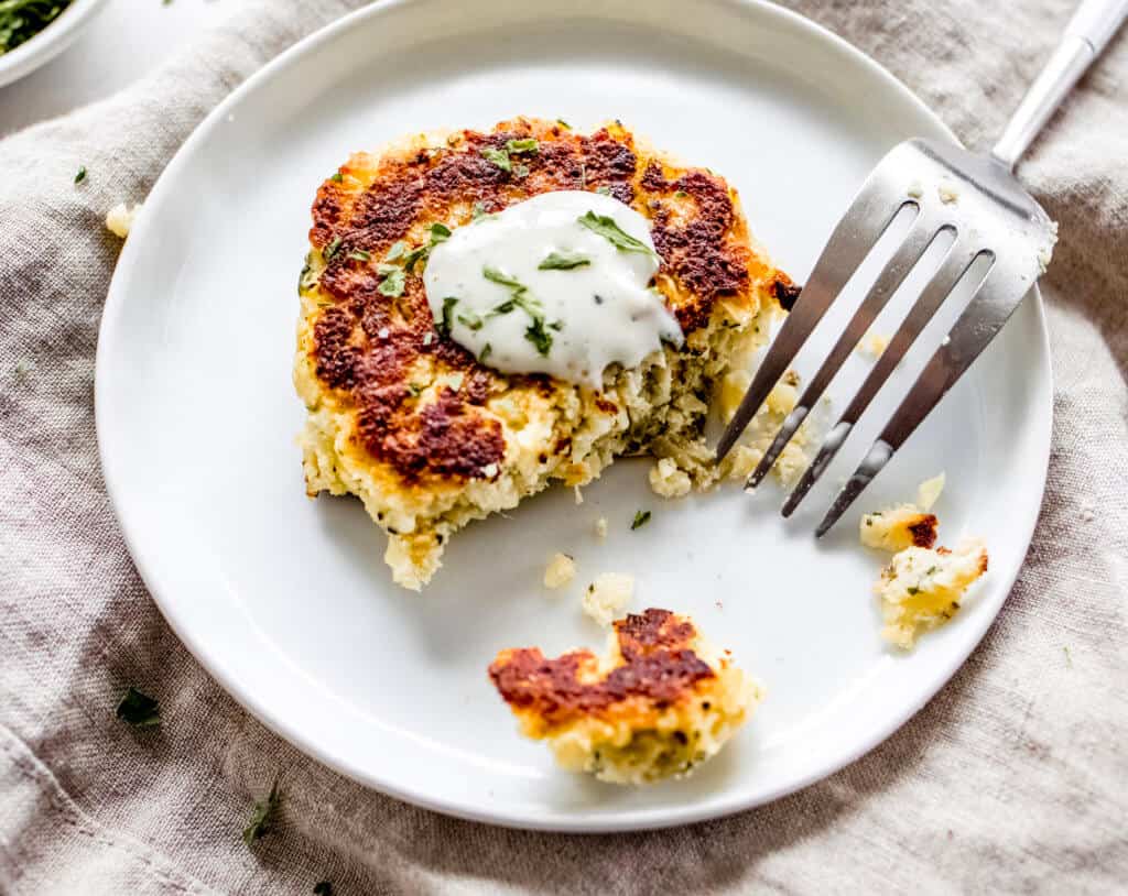 A circle tray of fritters made out of cauliflower and homemade ranch dressing