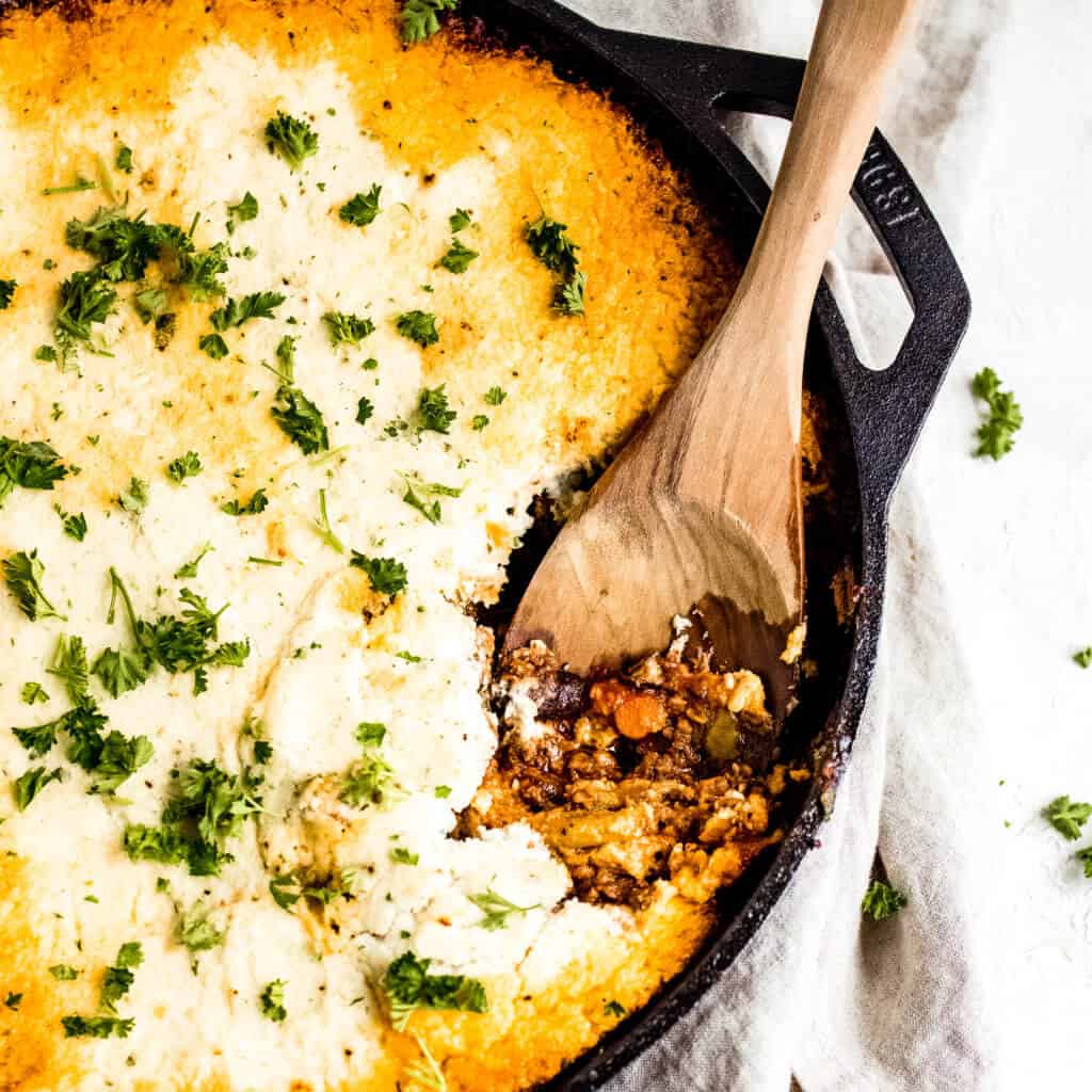 A overhead photo of the keto shepherd's pie topped with cauliflower mash with wooden spoon