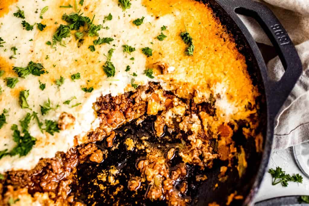 A close up photo of the keto Shepherd's pie showing the saucy ground beef, veggies, and mashed cauliflower topping