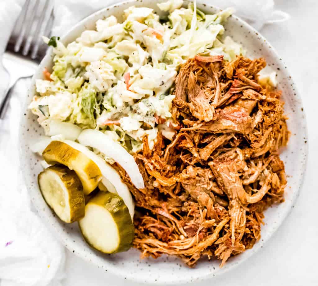 plated pulled pork with pickles, onions and ranch coleslaw