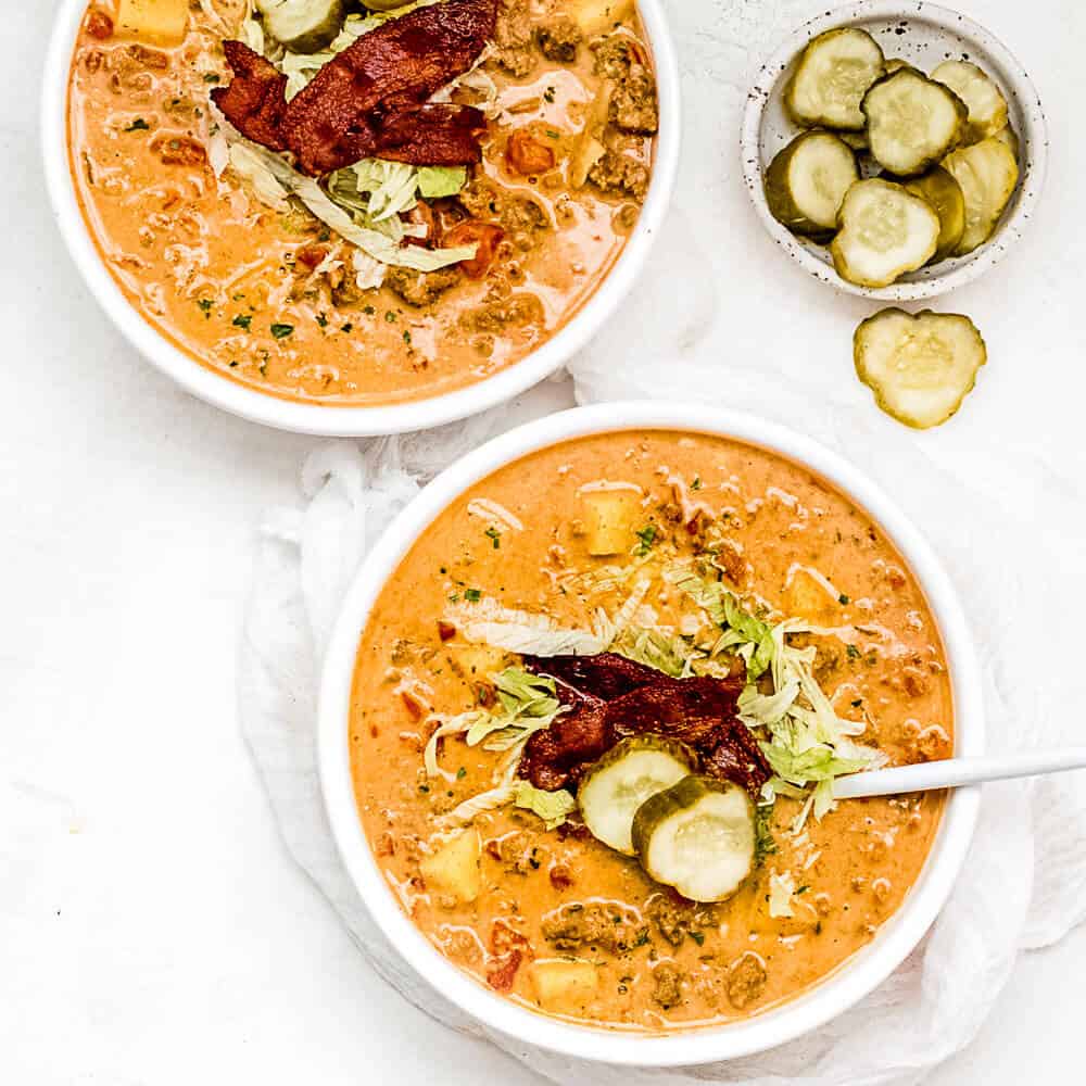 An overhead shot of the soup topped with a pickle and slice of bacon