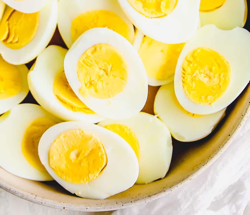 An close up photo of peeled and sliced hard-boiled eggs made in the air fryer