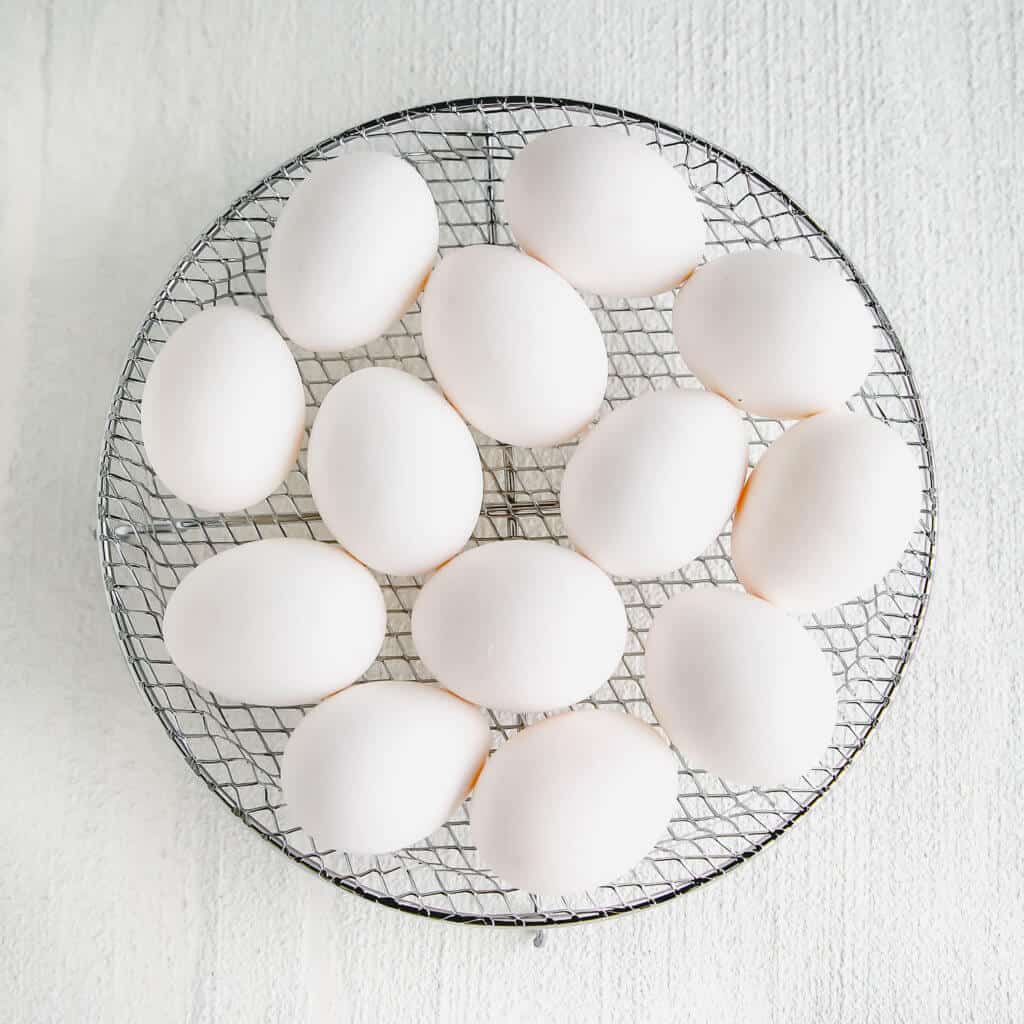 white eggs resting on a wire rack