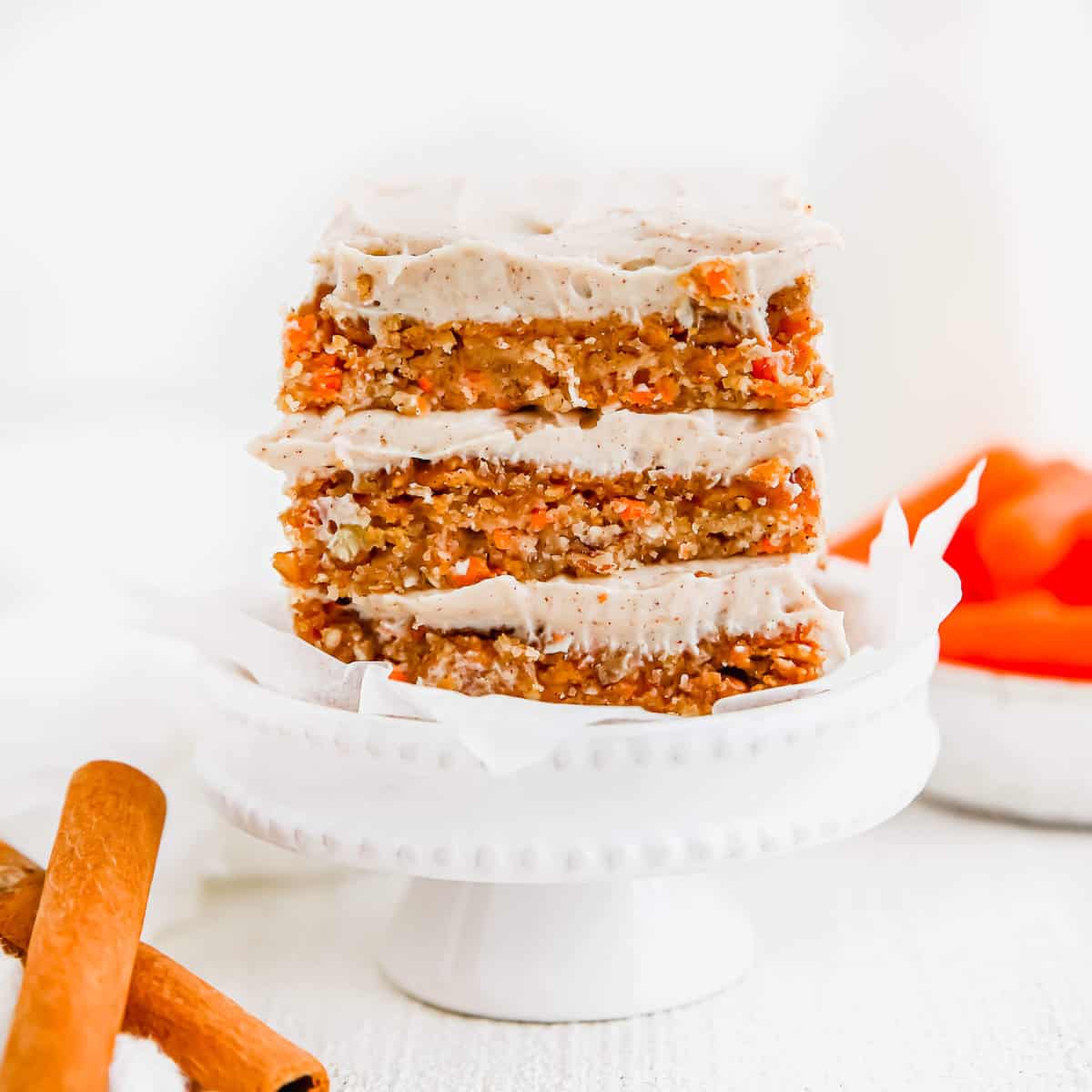 A stack of no bake carrot cake bars with cream cheese frosting