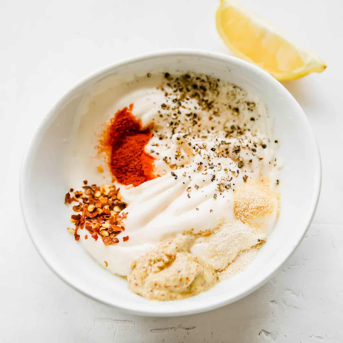 Keto fried green tomato zesty dipping sauce recipe ingredients in a small bowl.