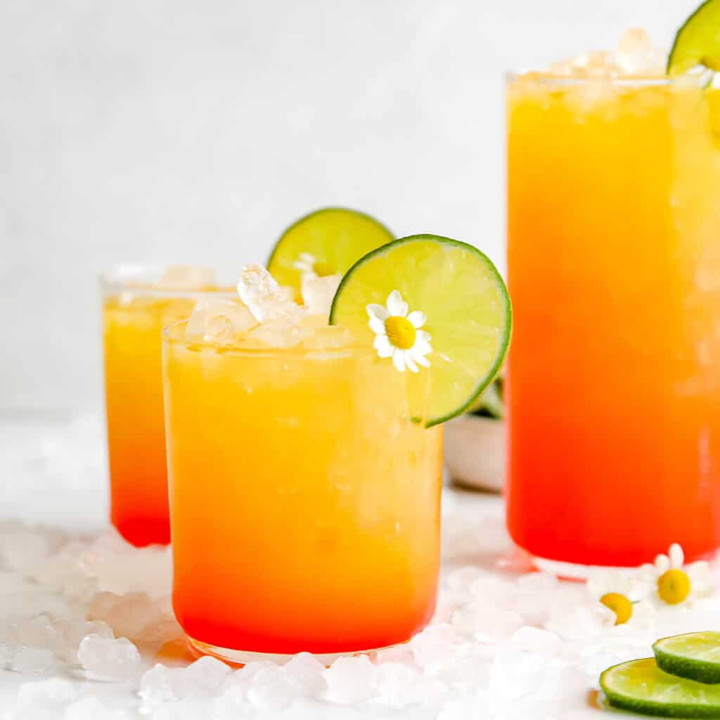 Pineapple Rum Punch Cocktails with flowers and lime slices