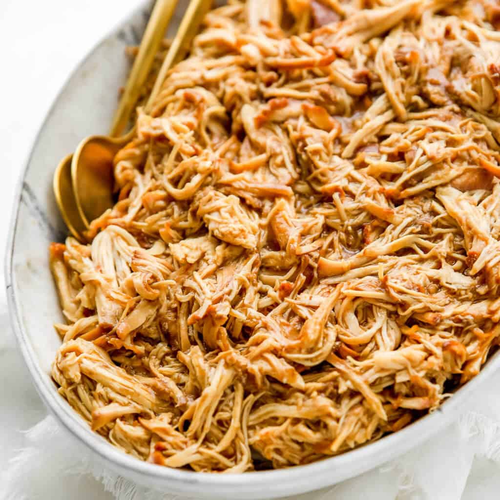 shredded chicken with sauce in a platter