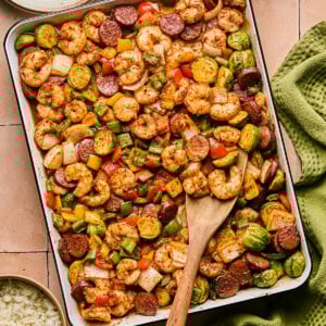 cajun shrimp and sausage on a sheet pan with veggies and seasoning