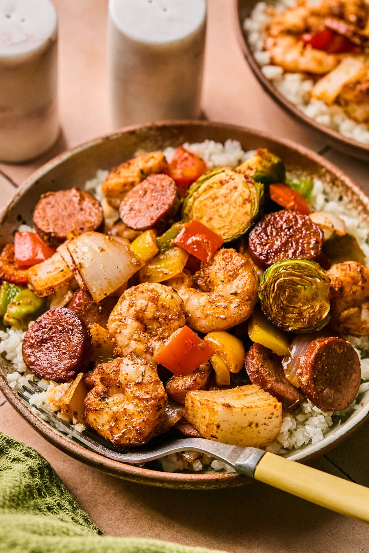 cajun shrimp and sausage served in a bowl with rice and veggies 