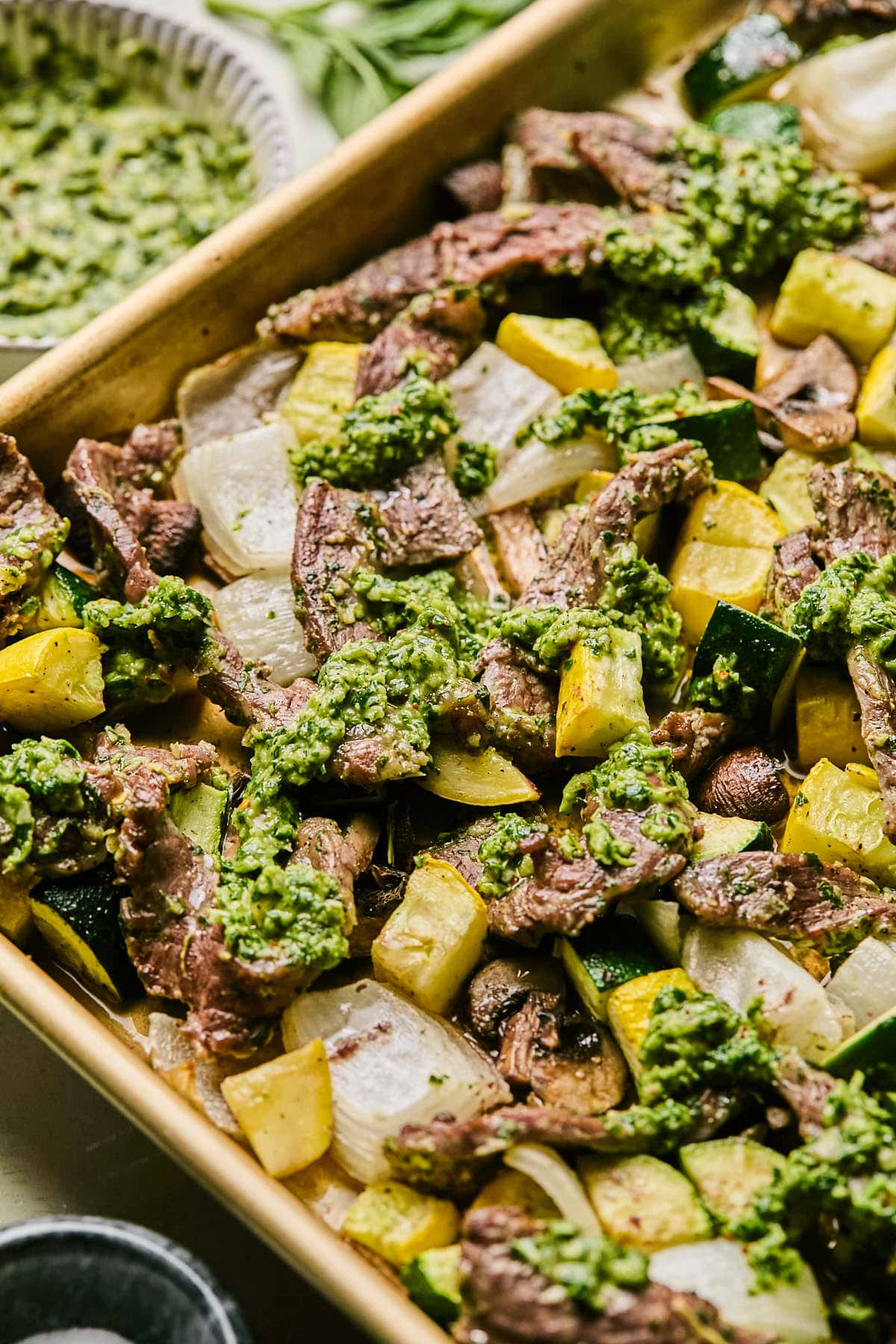 a close up of steak and veggies on a sheet pan 