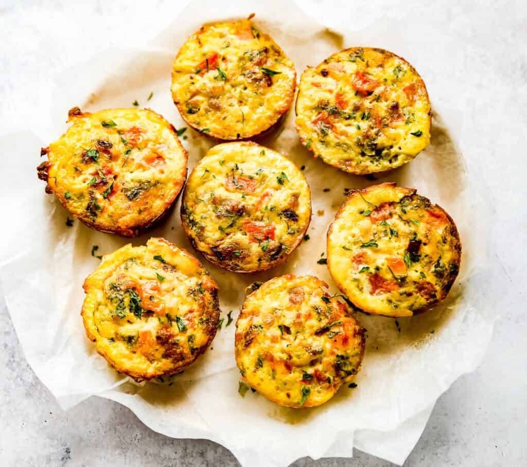 a large platter with egg muffins covered with fresh parsely