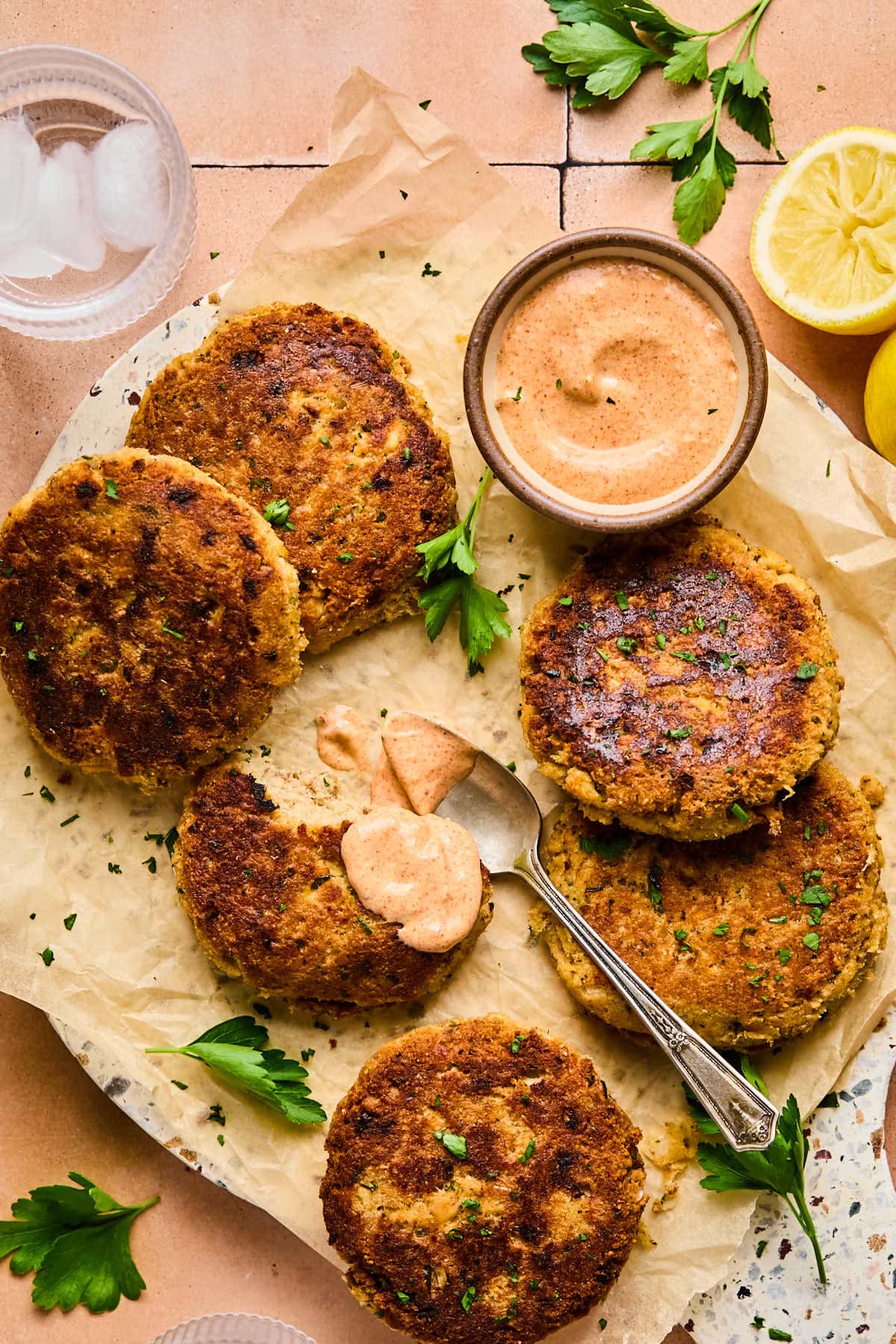 salmon patties on parchment paper with remoulade sauce on the side 