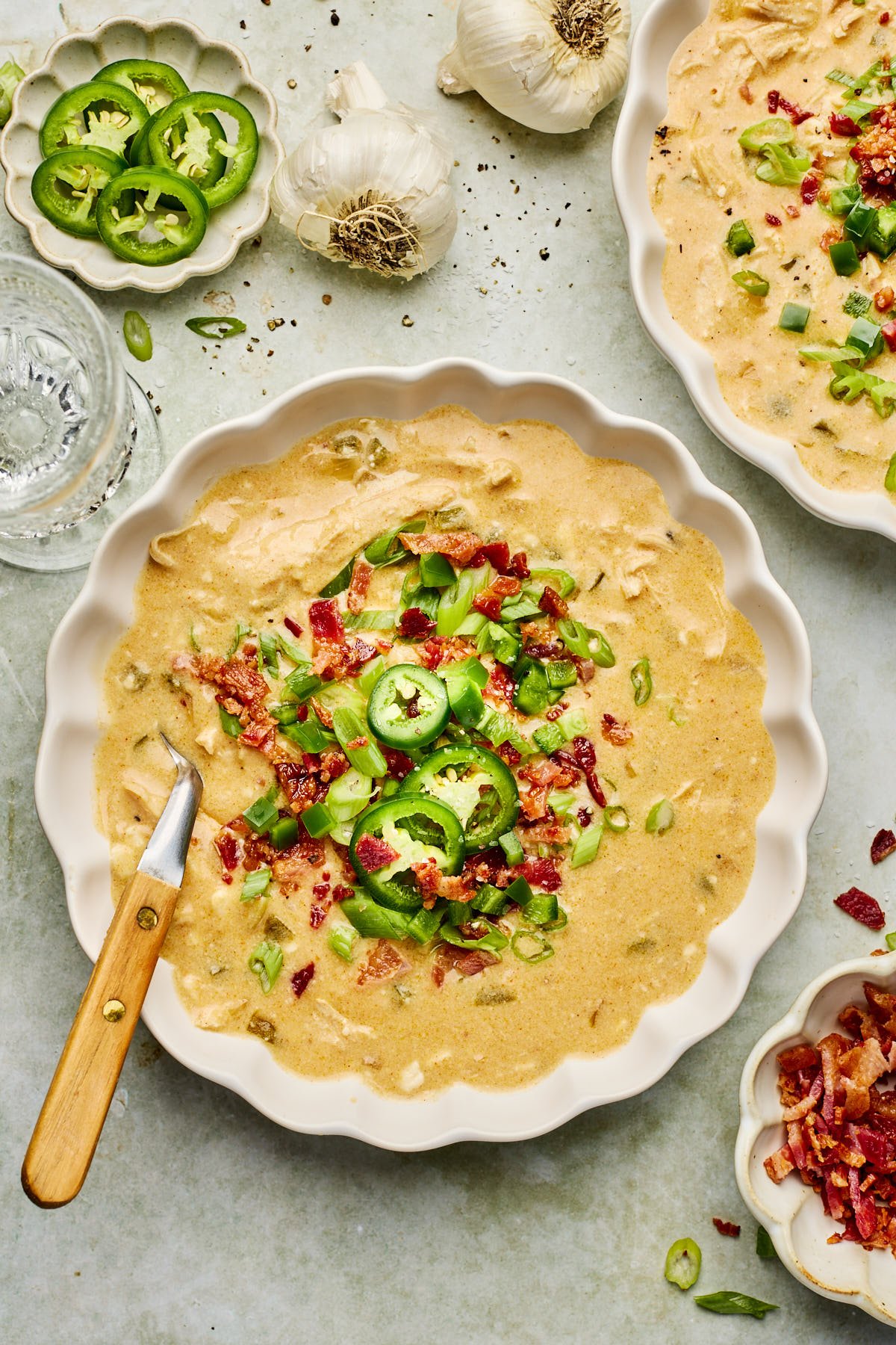 jalapeno popper soup in a white bowl with toppings