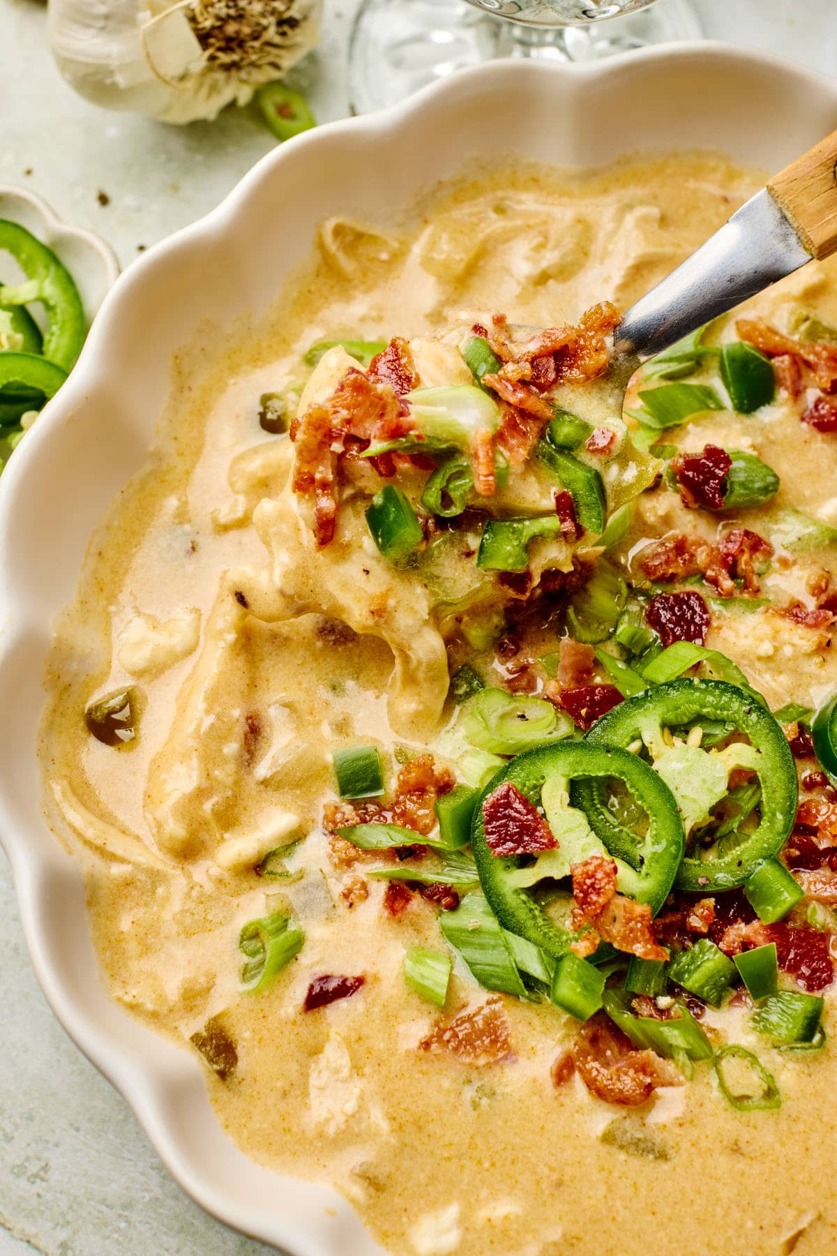 a close up shot of jalapeno popper soup with toppings