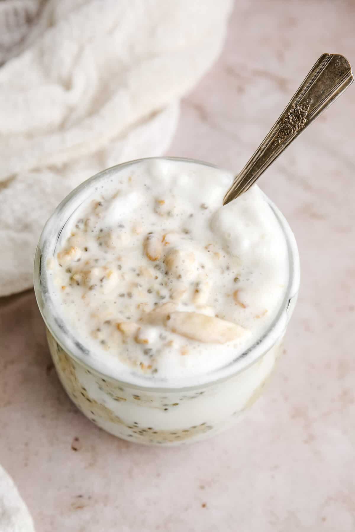 overhead view of protein overnight oats in a jar with a silver spoon