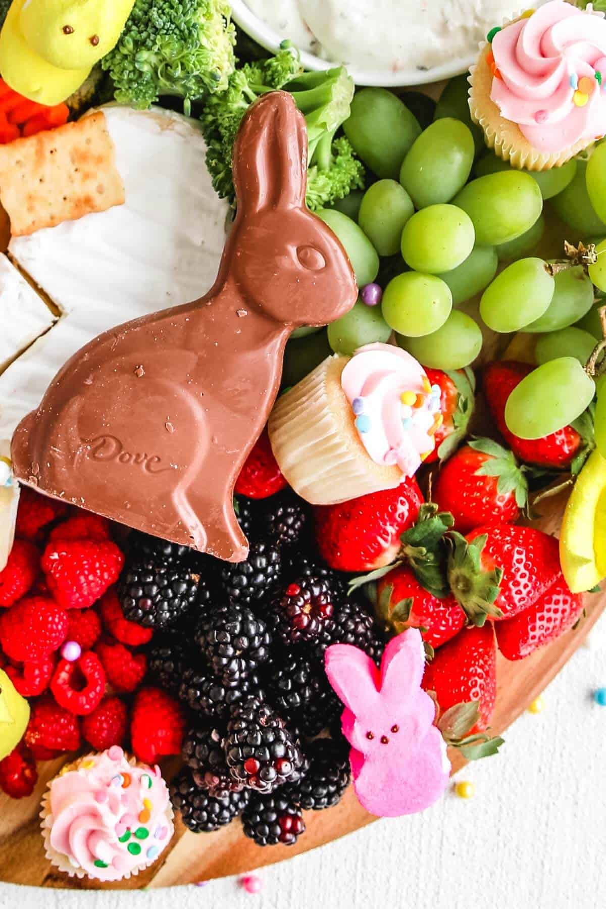 Charcuterie Board with fruit, cupcakes, crackers and chocolate