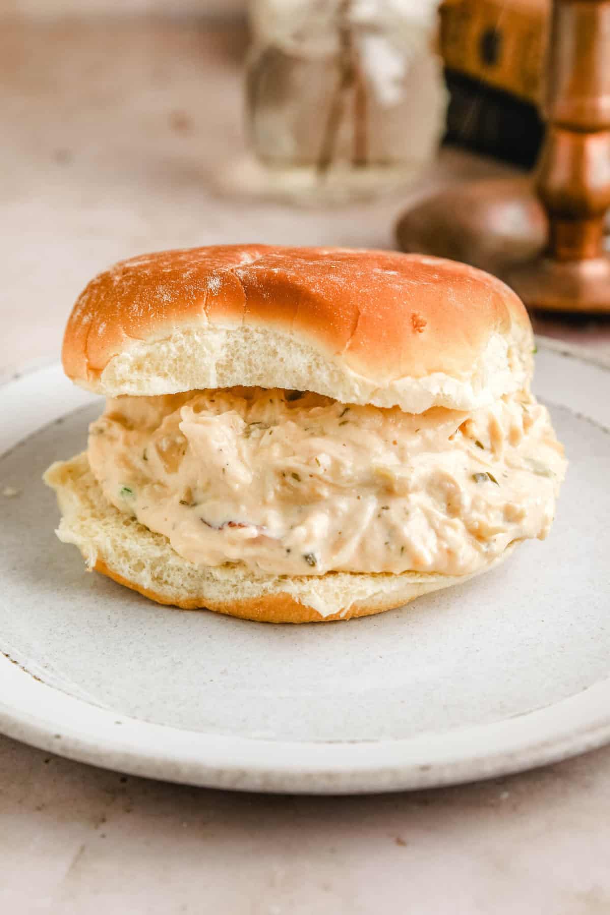 a bun on a plate stuffed with the creamy ranch chicken