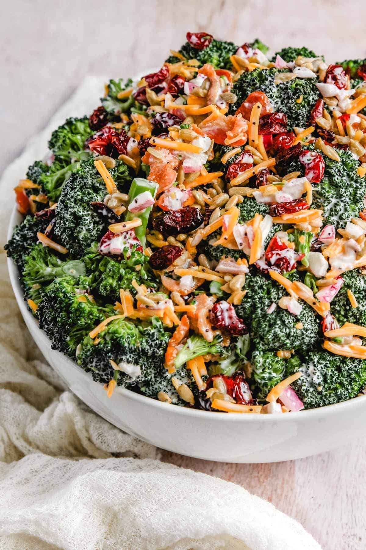 a close up photo of the creamy broccoli salad in a large serving bowl