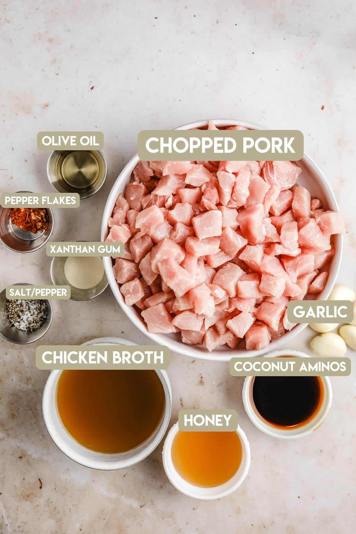 ingredients needed to make chopped pork bites with garlic honey sauce in metal and white bowls