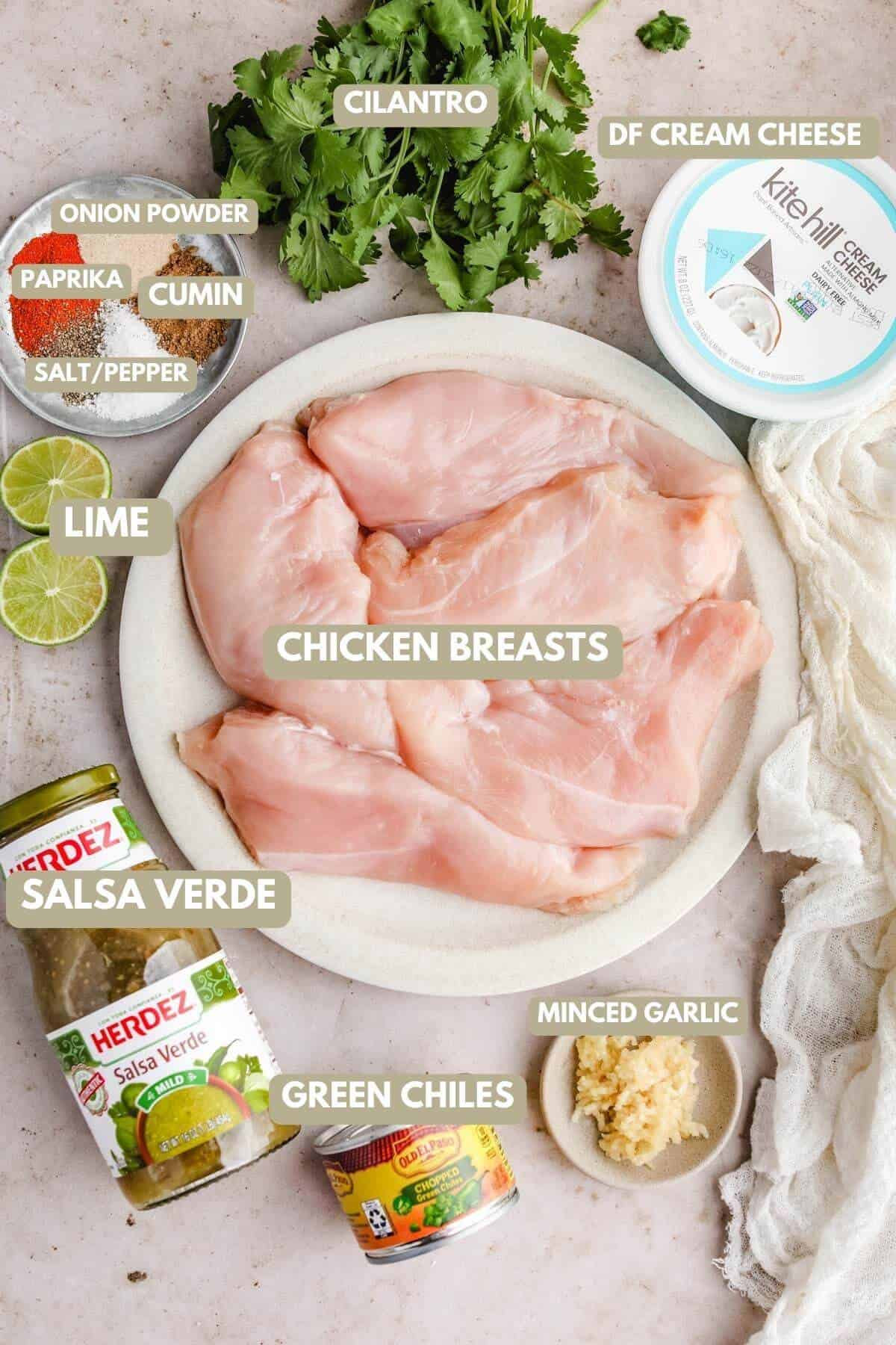 a photo with recipe ingredients labeled, including herdez salsa verde, chicken breasts, minced garlic, green chiles, lime, spices, dairy free cream chese, and fresh cilantro