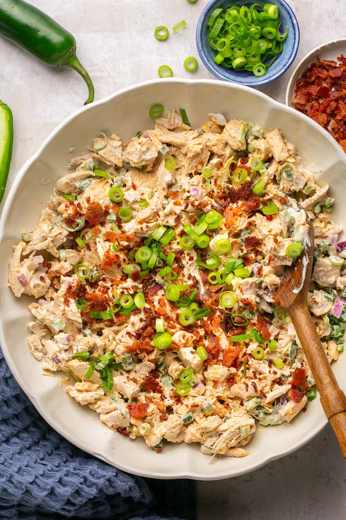 A close up photo of the Jalapeno Popper Chicken Salad topped with crumbled bacon and green onions