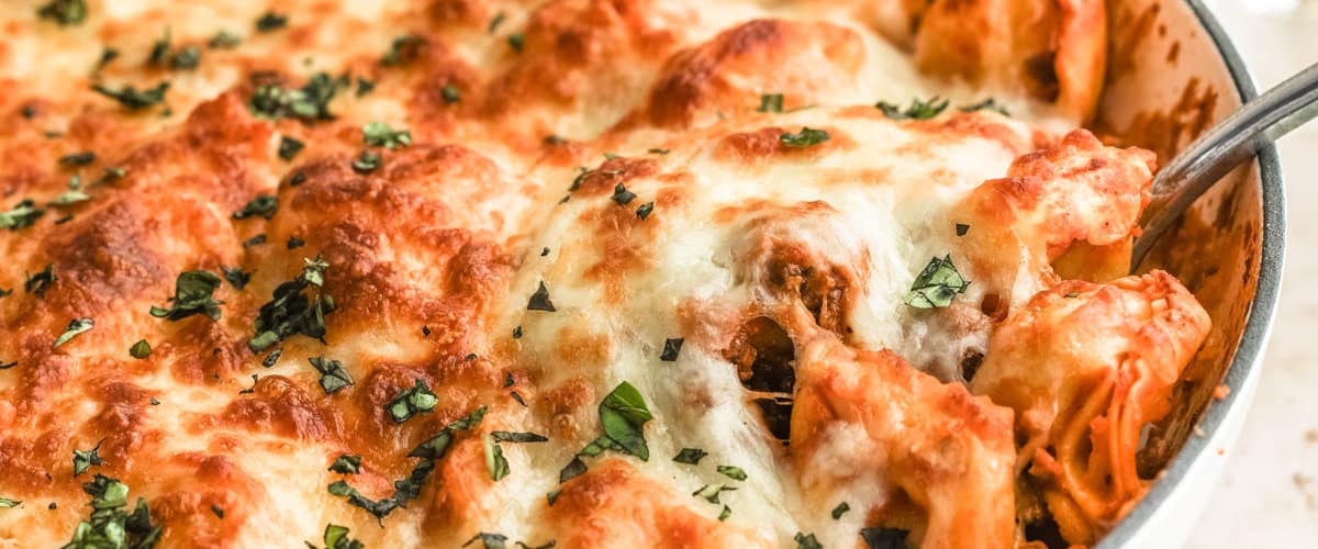 a closeup photo of a serving spoon spooning out pasta