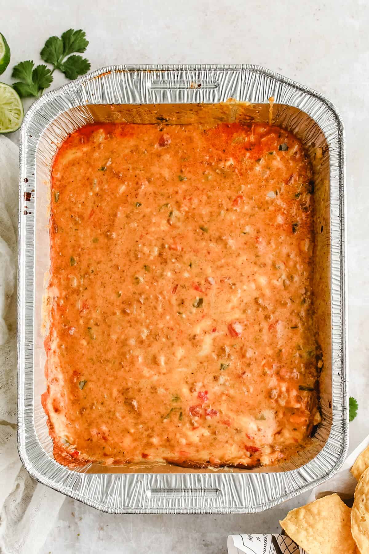 melted smoked queso in a foil pan
