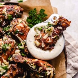 a chicken wing getting dipped into ranch dressing