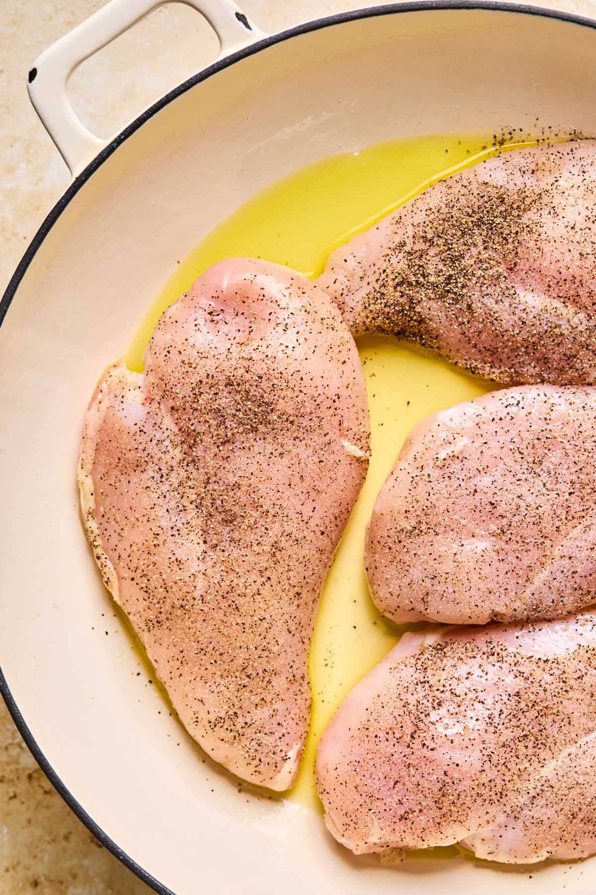 raw chicken in a pan with olive oil 