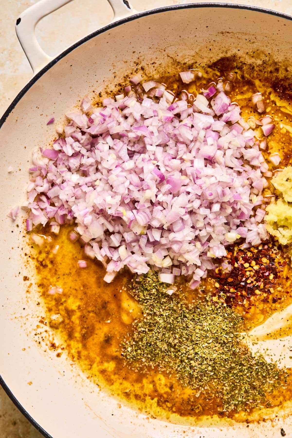 sauteeing onions, garlic, and seasonings in a skillet to prepare the sauce. 