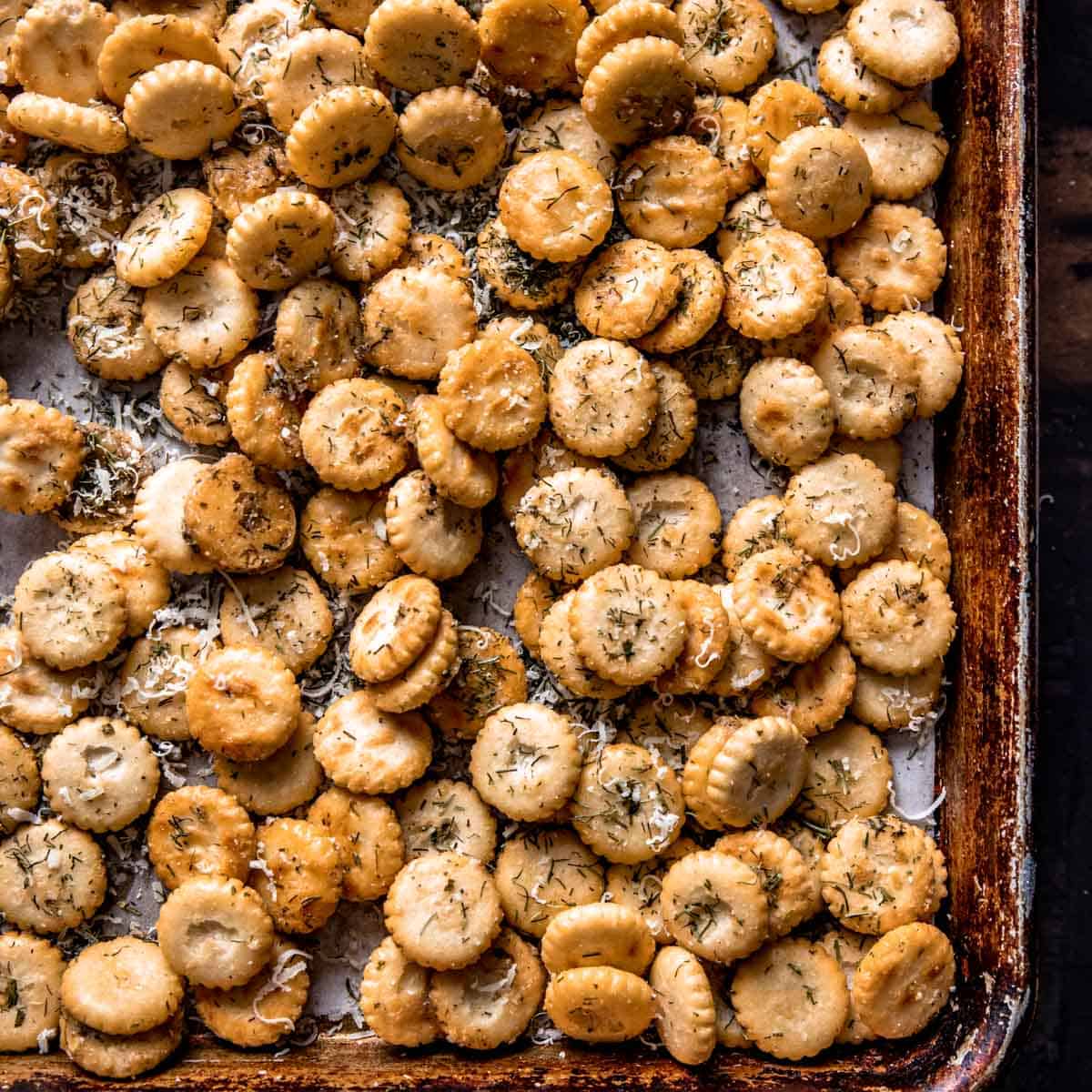 a close up of seasoned oyster crackers on a lined baking sheet