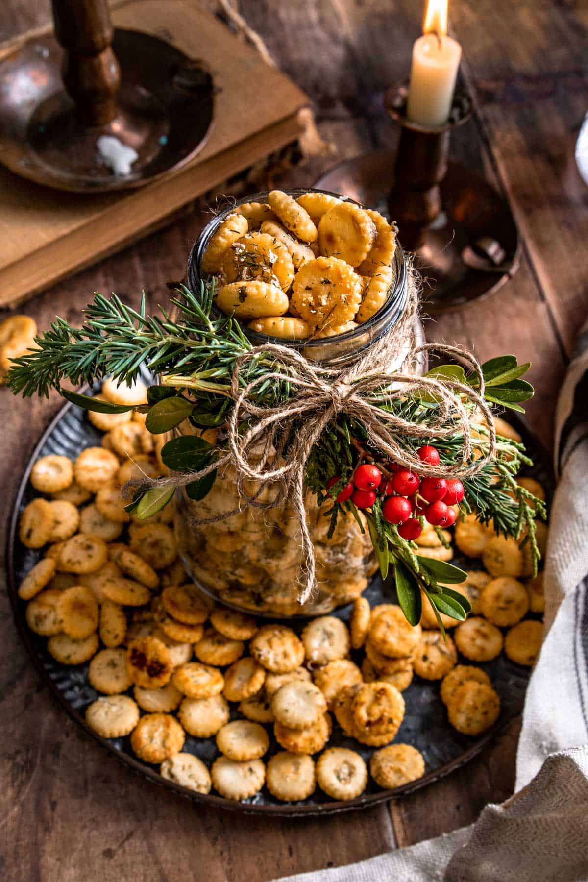 a festive mason jar filled with crackers on a plate surrounded by more crackers. 