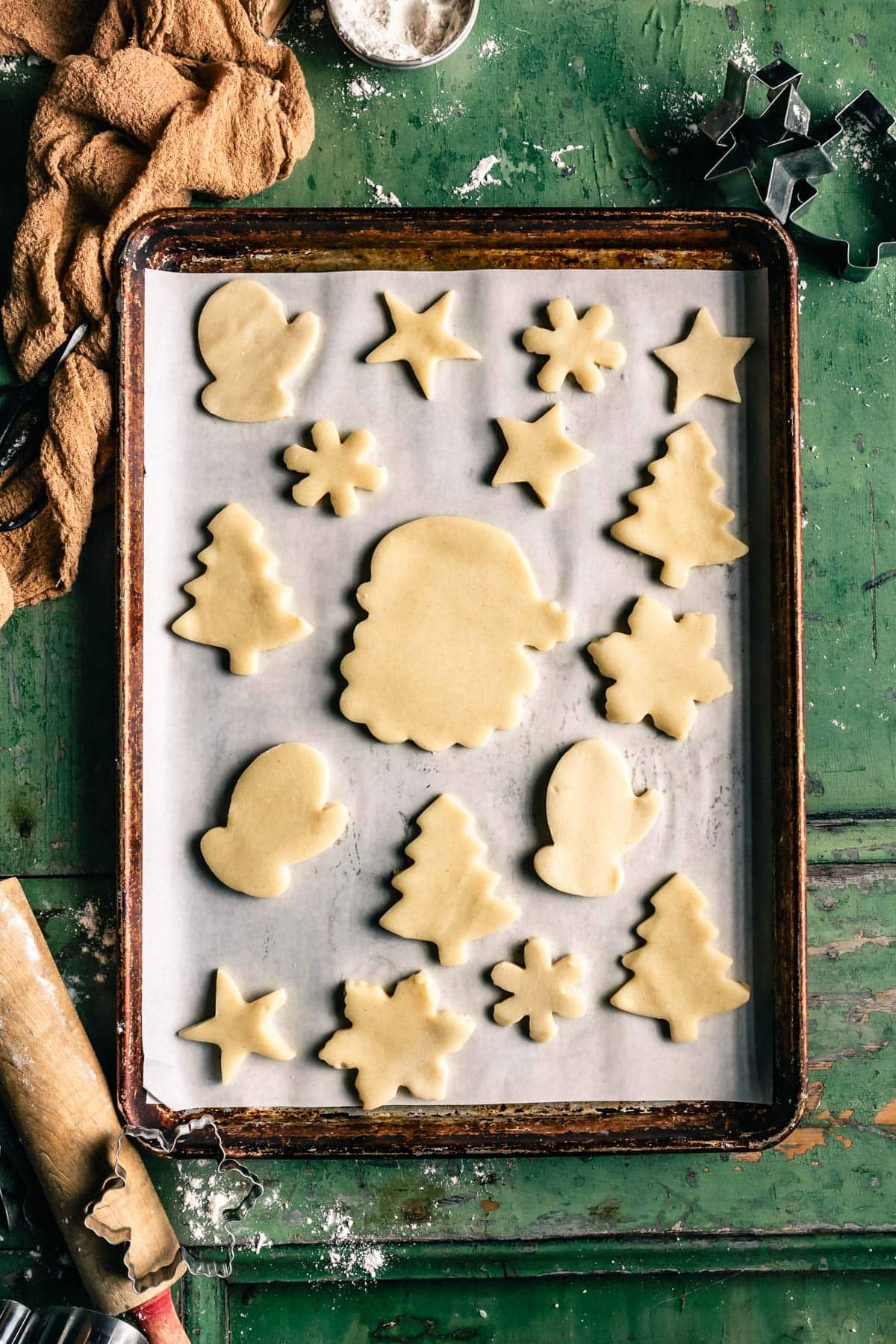 gluten free cookie dough cute into christmas shapes. On a baking sheet pan getting ready to be baked