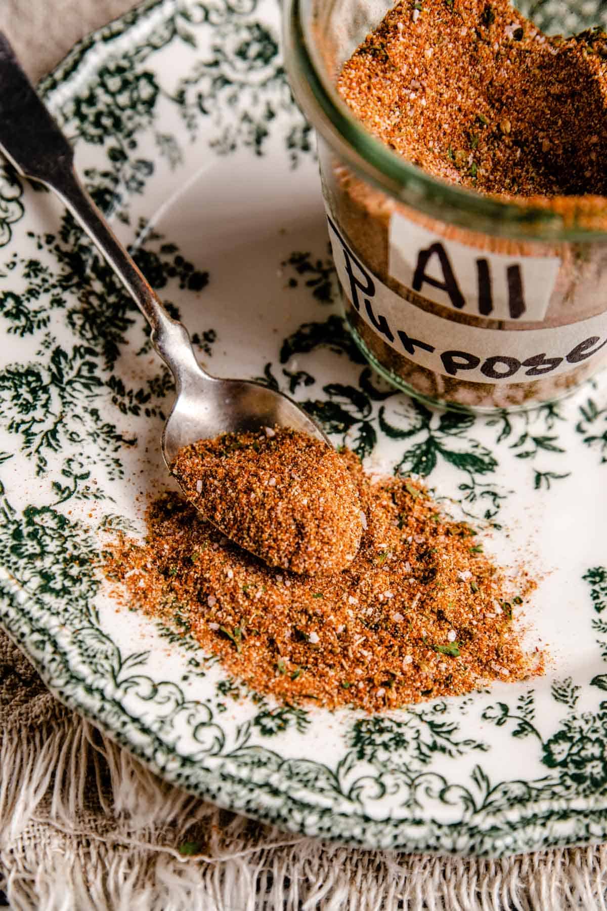 a spoon showing the contents of a homemade all purpose seasoning blend.