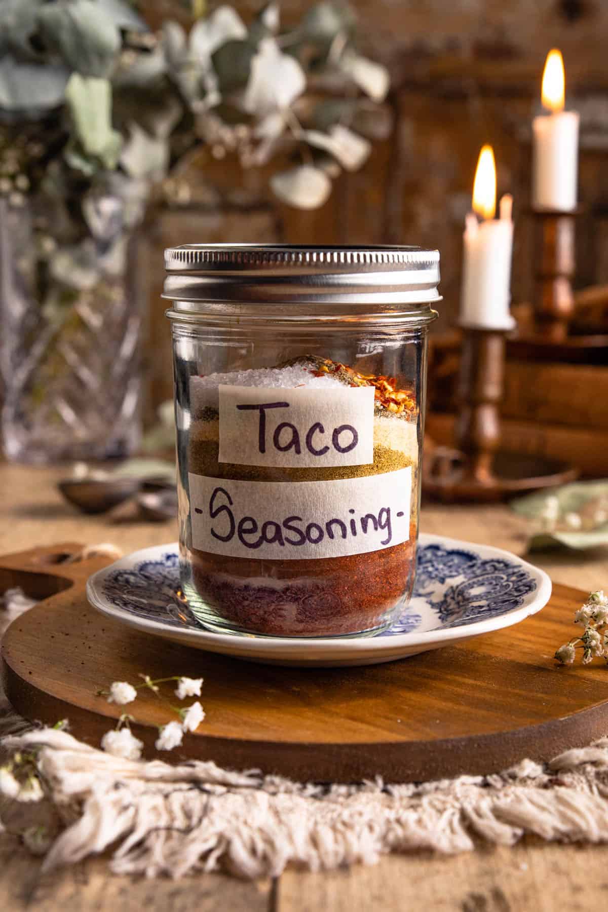 a mason jar labeled taco seasoning on a blue and white plate